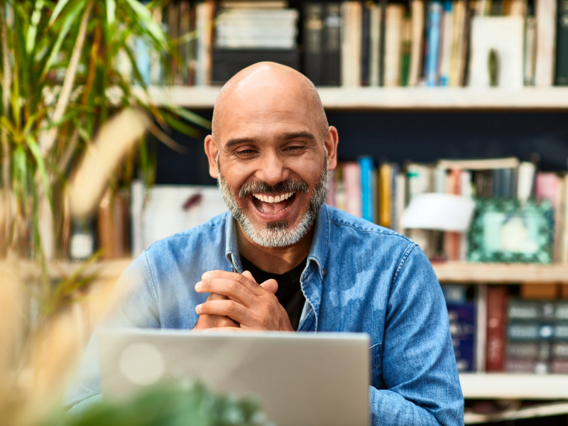 Mature-man-laughing-and-smiling-on-video-conference